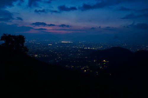 Free Stunning twilight capture of city skyline with vibrant evening lights against hills. Stock Photo