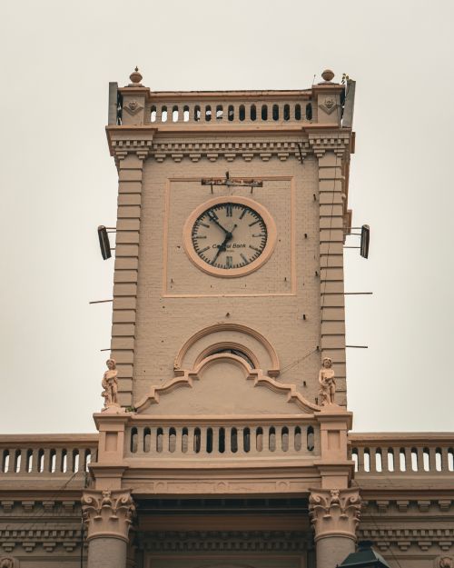 Free A close-up view of a historic clock tower with ornamental details under an overcast sky. Stock Photo
