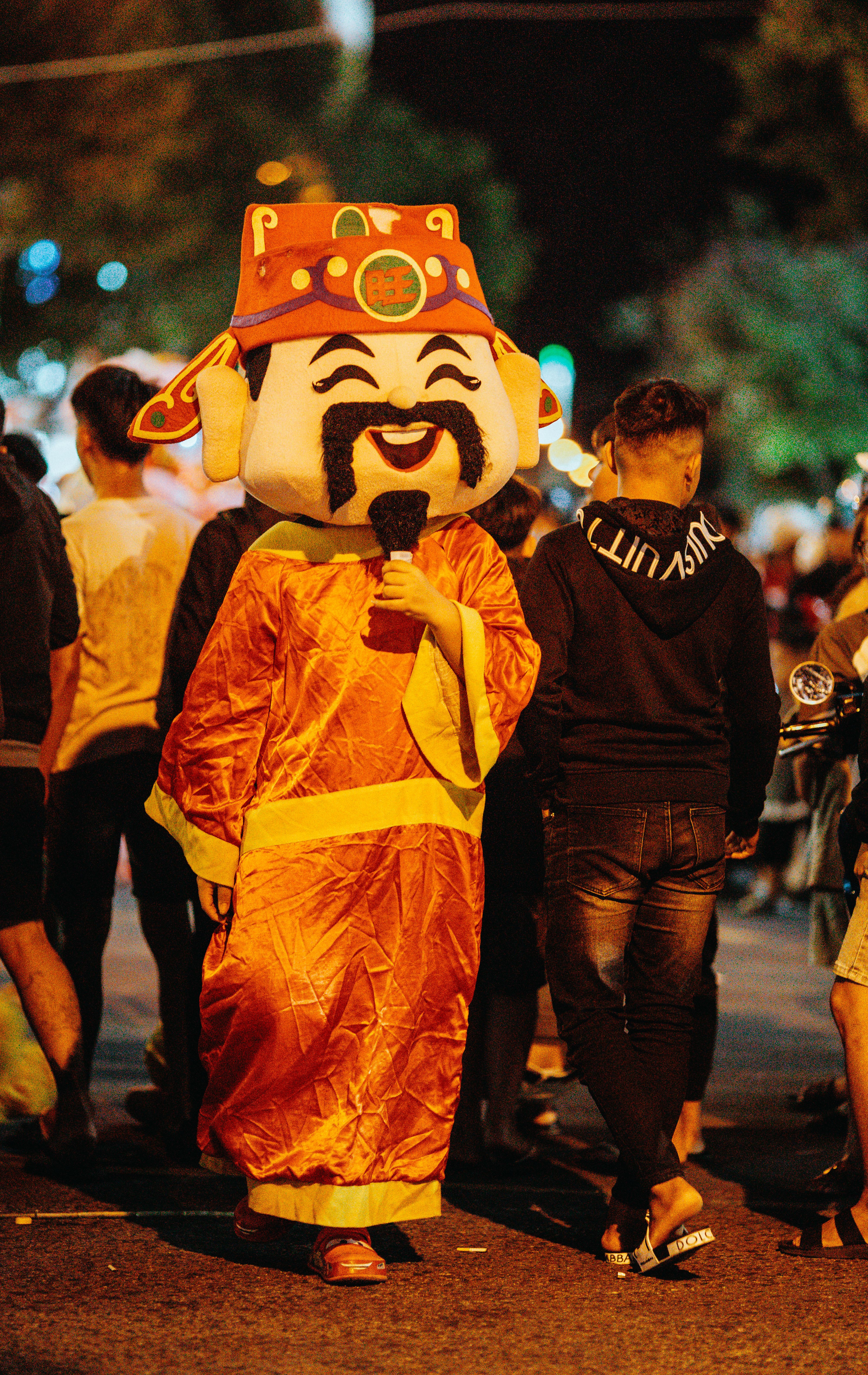 Street festival in Vietnam featuring a vibrant traditional costume parade during the night.