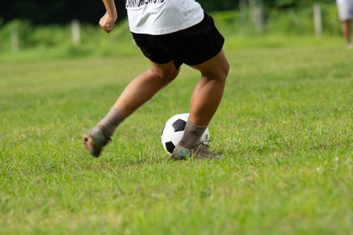 Free A young person playing football outdoors in Myanmar, showcasing athleticism and fun. Stock Photo