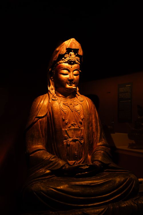 Free A beautifully crafted Buddha statue illuminated by warm lighting, exuding peace and serenity. Stock Photo