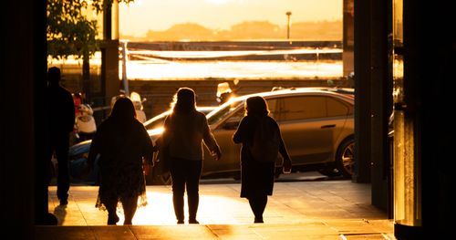 Free Silhouetted figures walking through a sunlit corridor in Istanbul at sunset. Stock Photo