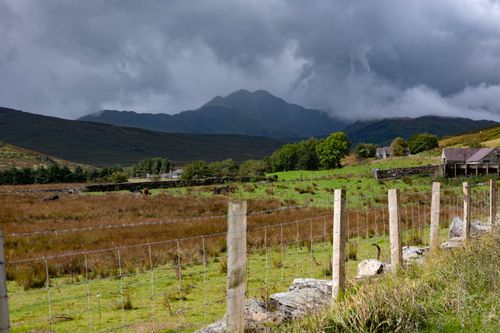 Free Picturesque landscape of Snowdonia with lush fields and dramatic skies in Wales. Stock Photo