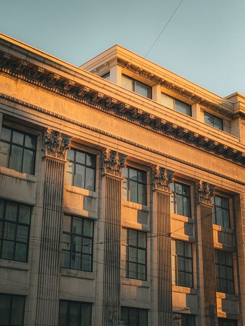 Free Sunlit facade of a classical architectural building captured at sunset, showcasing elegant columns and design. Stock Photo