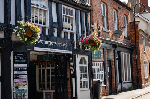 Free Charming Tudor architecture with flower baskets in Whitchurch, England, on a sunny day. Stock Photo