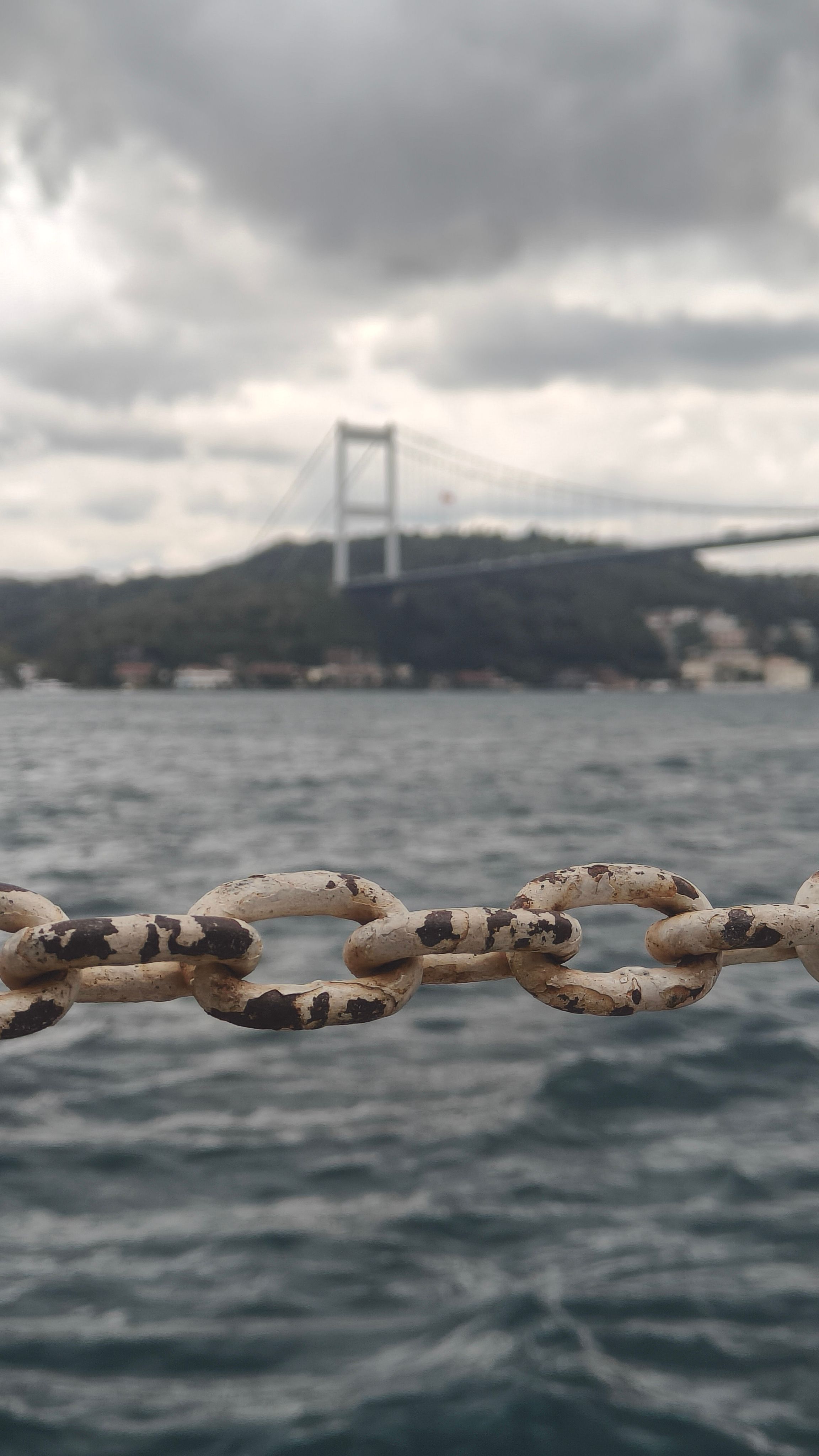 Close-up of a rusty chain with the Bosphorus Bridge in the background, Istanbul.