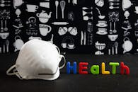 厨房背景上的口罩和彩色健康文字