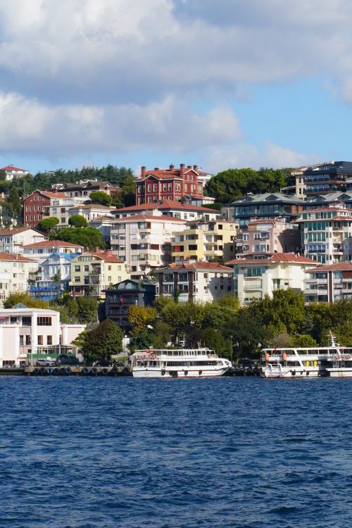 Free Vibrant cityscape featuring diverse urban architecture along a lively waterfront. Stock Photo