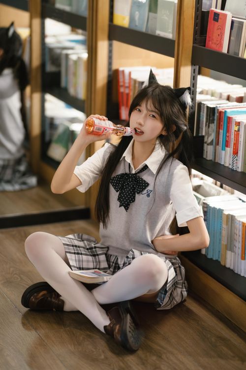 Free Cosplay student sits in a library aisle with stylish costume, sipping a drink. Stock Photo