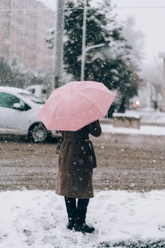 冬天，在乌兹别克斯坦撒马尔罕的雪中，一位女士撑着一把粉红色的雨伞。 - 相关推荐