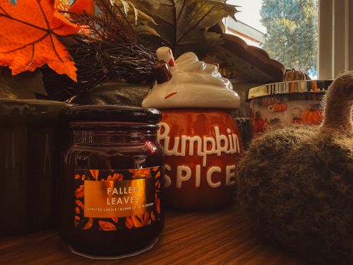 Free Warm autumn decor featuring candles, pumpkins, and fall leaves in a cozy home setting. Stock Photo