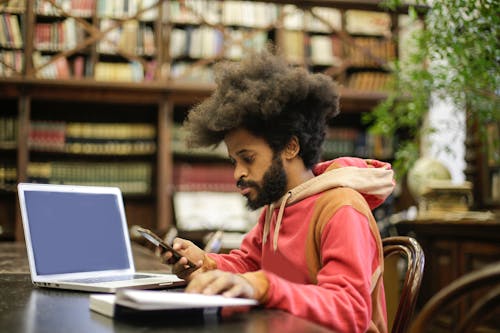 Man in Pink Long Sleeve Shirt Doing Research