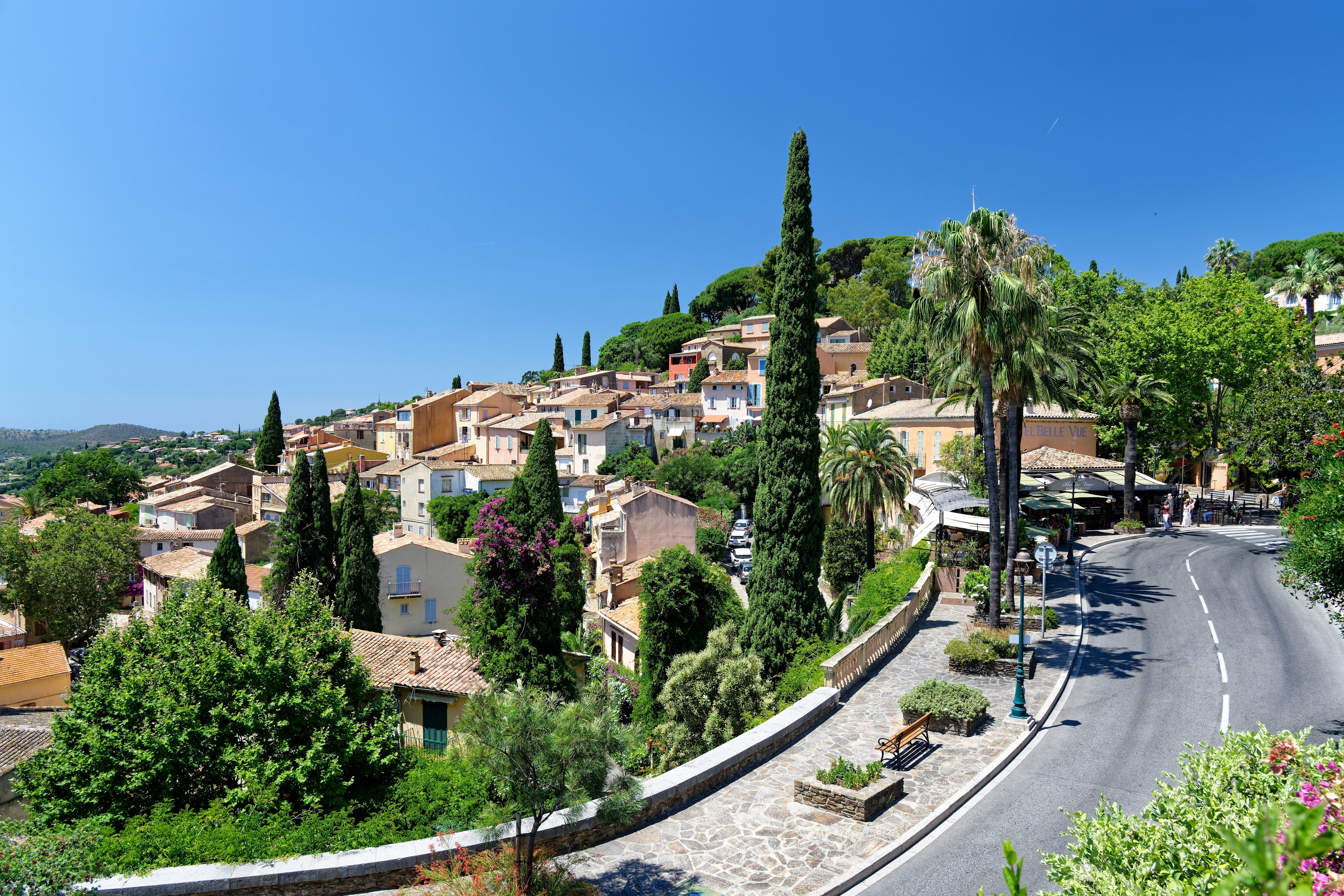 Scenic view of a picturesque village in the French Riviera with lush greenery and clear blue skies.