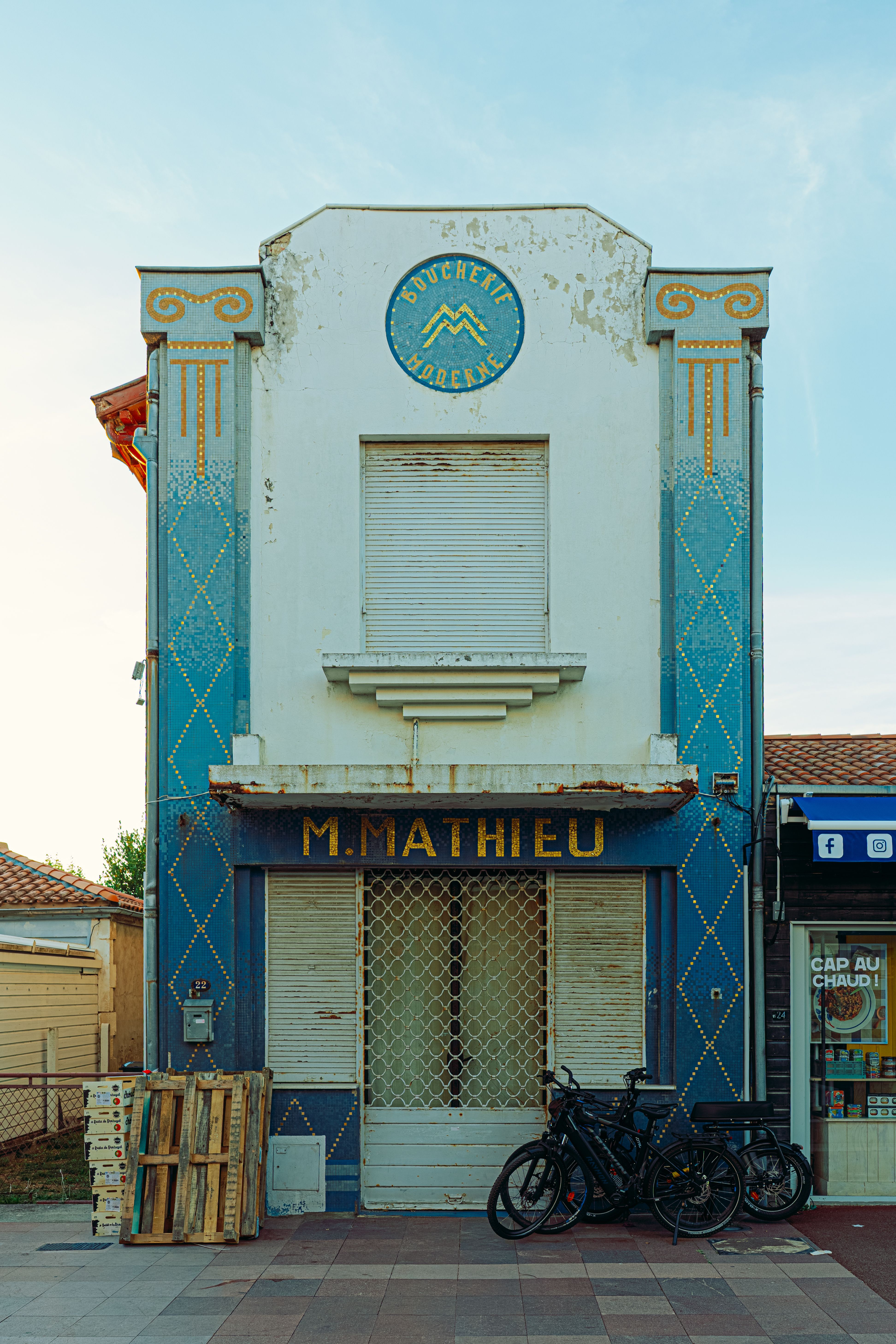 Historic storefront with vintage architecture in a French town, featuring bicycles parked outside.