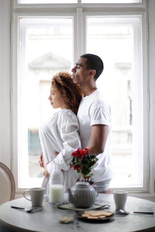 Free Loving couple hugging near window during breakfast at home Stock Photo