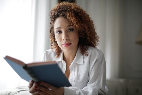 Free Woman in White Dress Shirt Holding Book Stock Photo