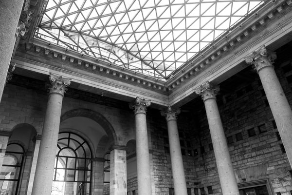 Grand atrium à colonnes corinthiennes et toit de verre, en noir et blanc