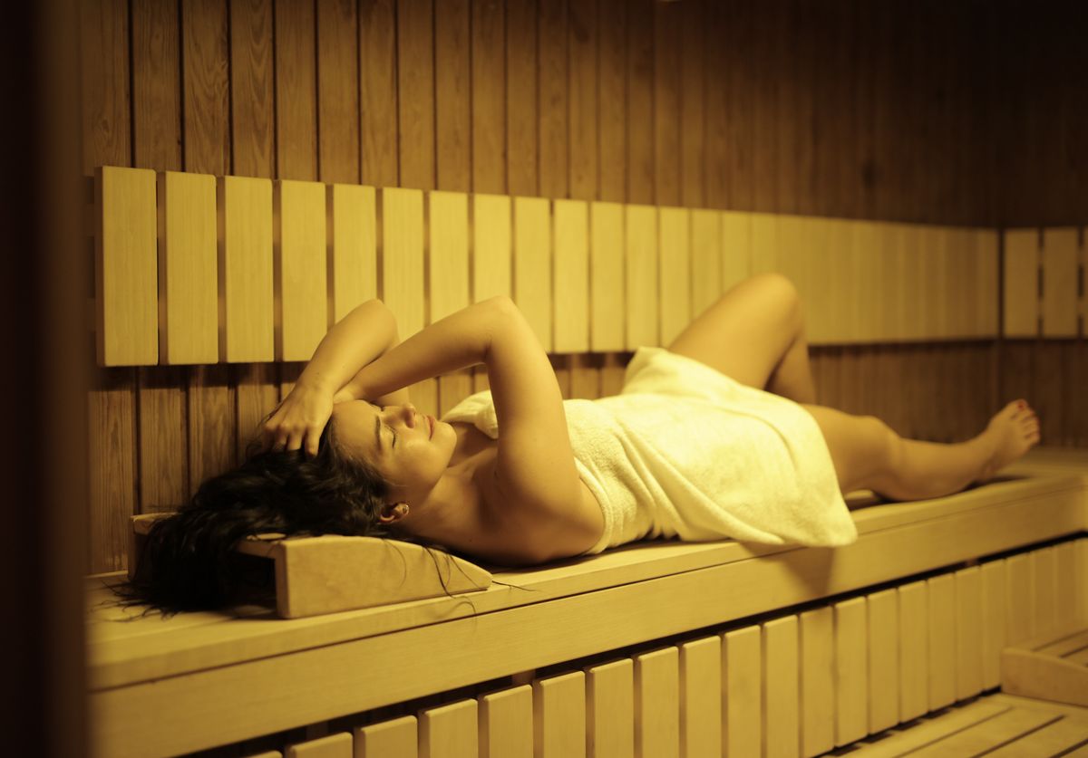 A person relaxing in a wooden sauna, a neutral visual for the heat-room side of a Korean jjimjilbang.