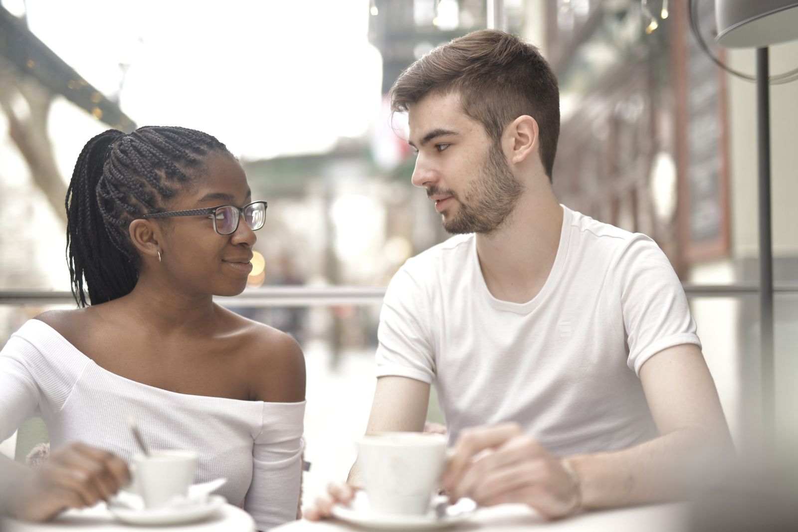 Young couple having a warm conversation over coffee in a bright cafe