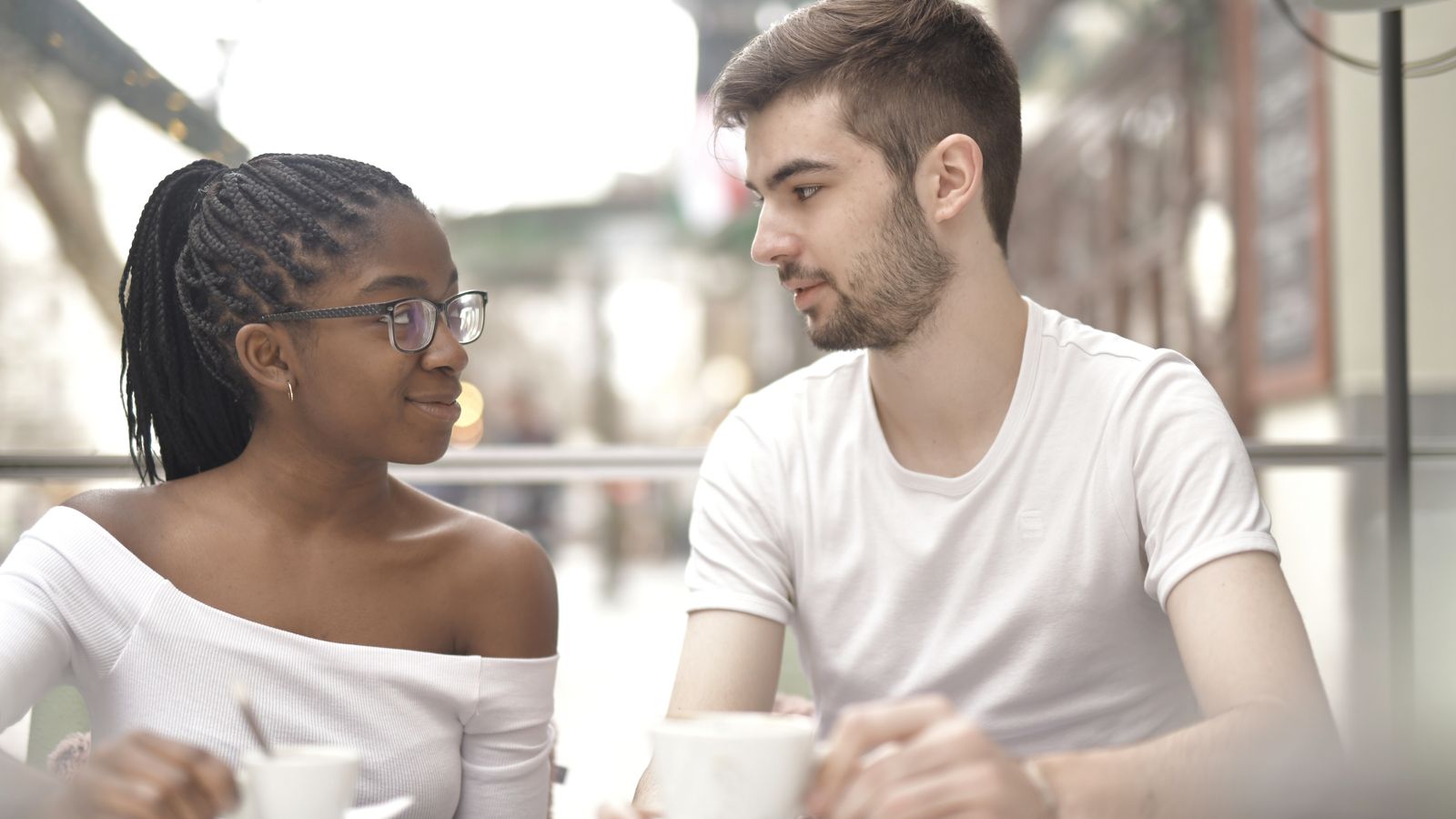 Two adults talking over coffee in a café