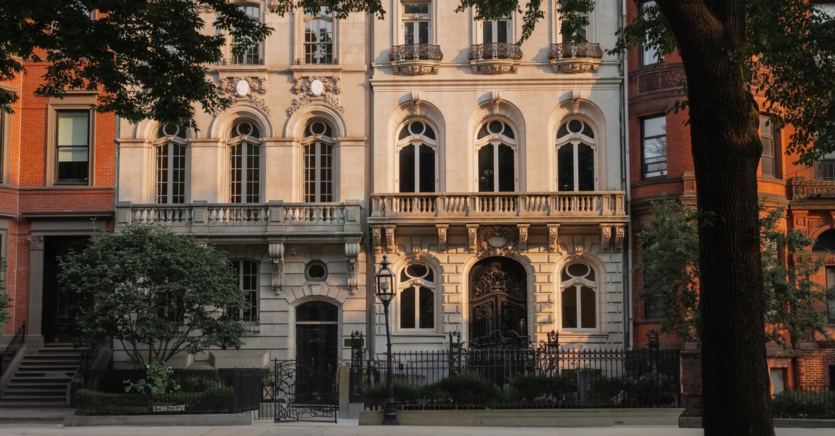 Historic architectural facade basking in sunset light, surrounded by city greenery.