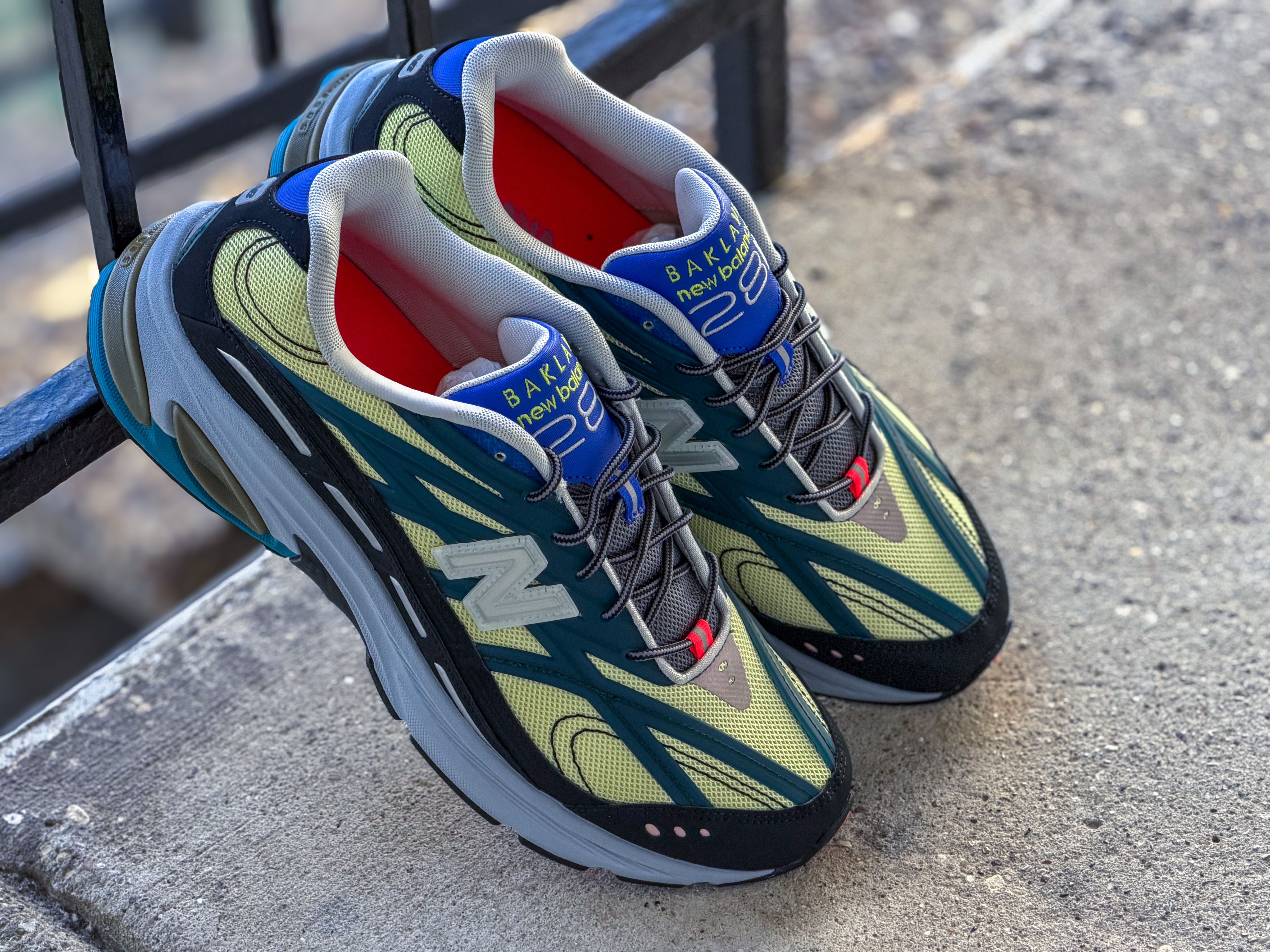 Vibrant New Balance sneakers displayed on concrete, showcasing stylish design.
