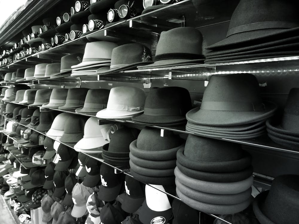 Black and white image of hats on wall shelf