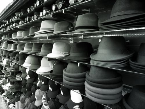 Free Aesthetic black and white shot featuring rows of hats on shelves in a store. Stock Photo
