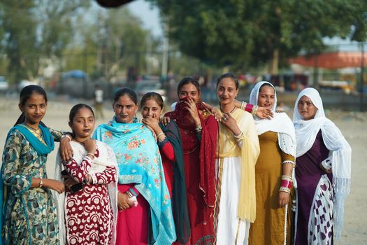 A group of women wearing vibrant traditional clothing posing outdoors, capturing cultural diversity.