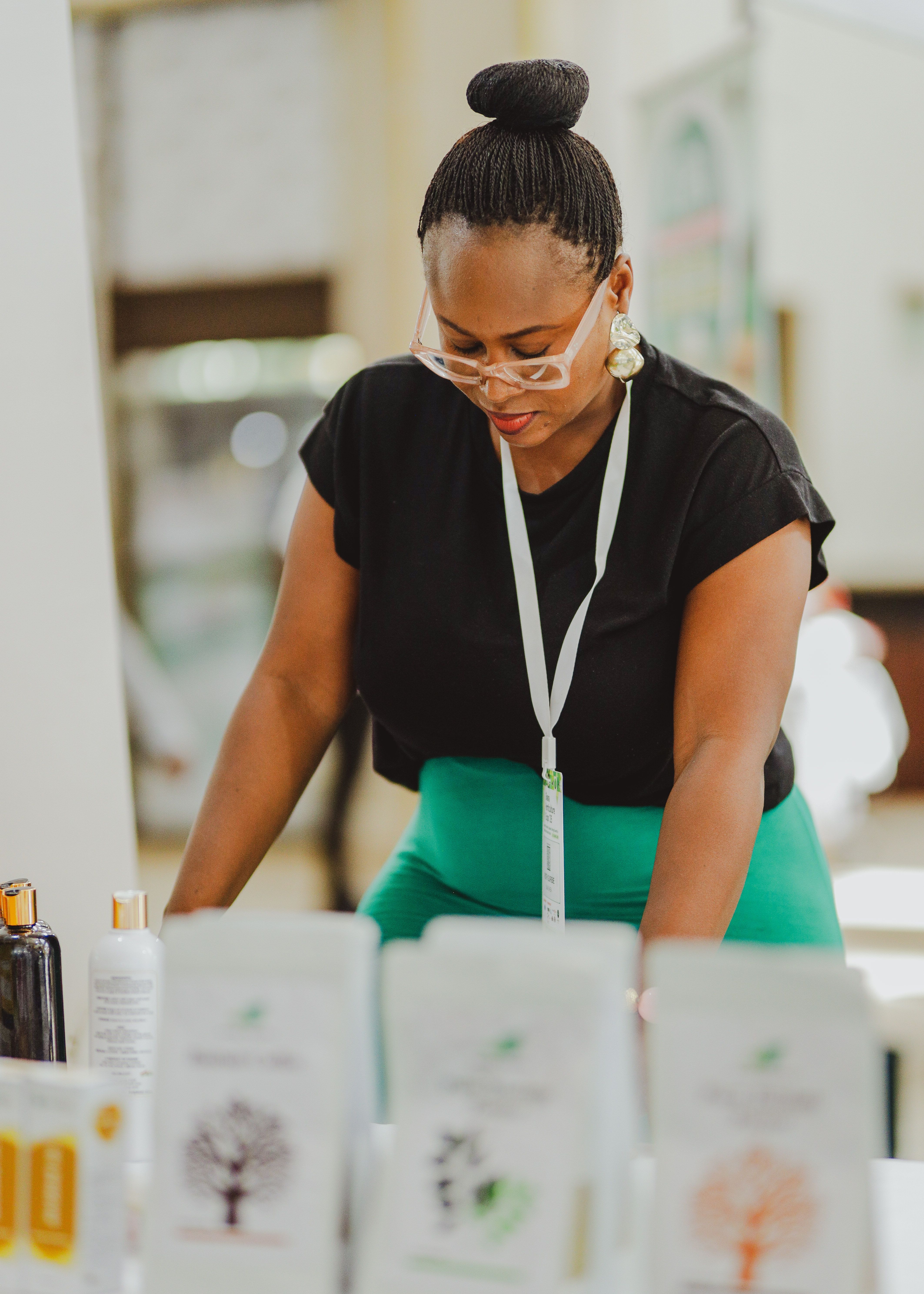 Confident African woman organizing products at a business event in Accra.