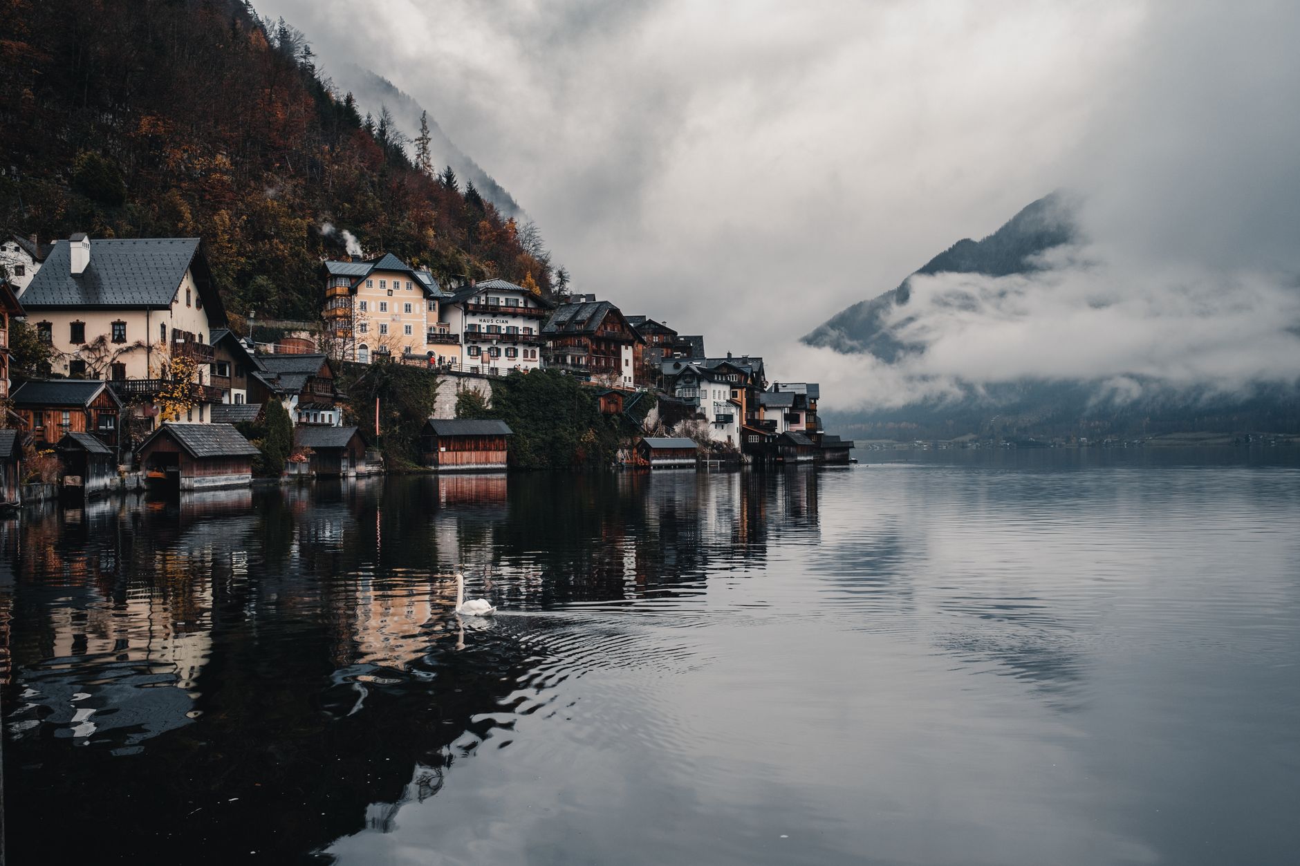 Picturesque Hallstatt village with misty mountains and calm waters creating a serene atmosphere.