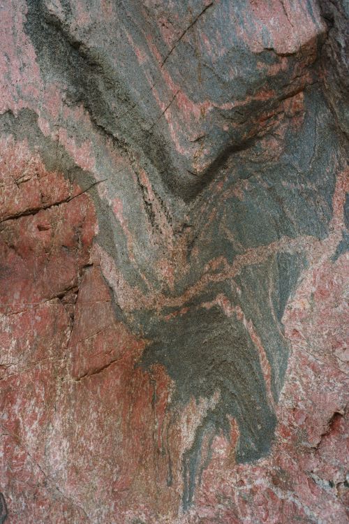 Free Striking red and green layered rock texture showcasing natural geological patterns. Stock Photo