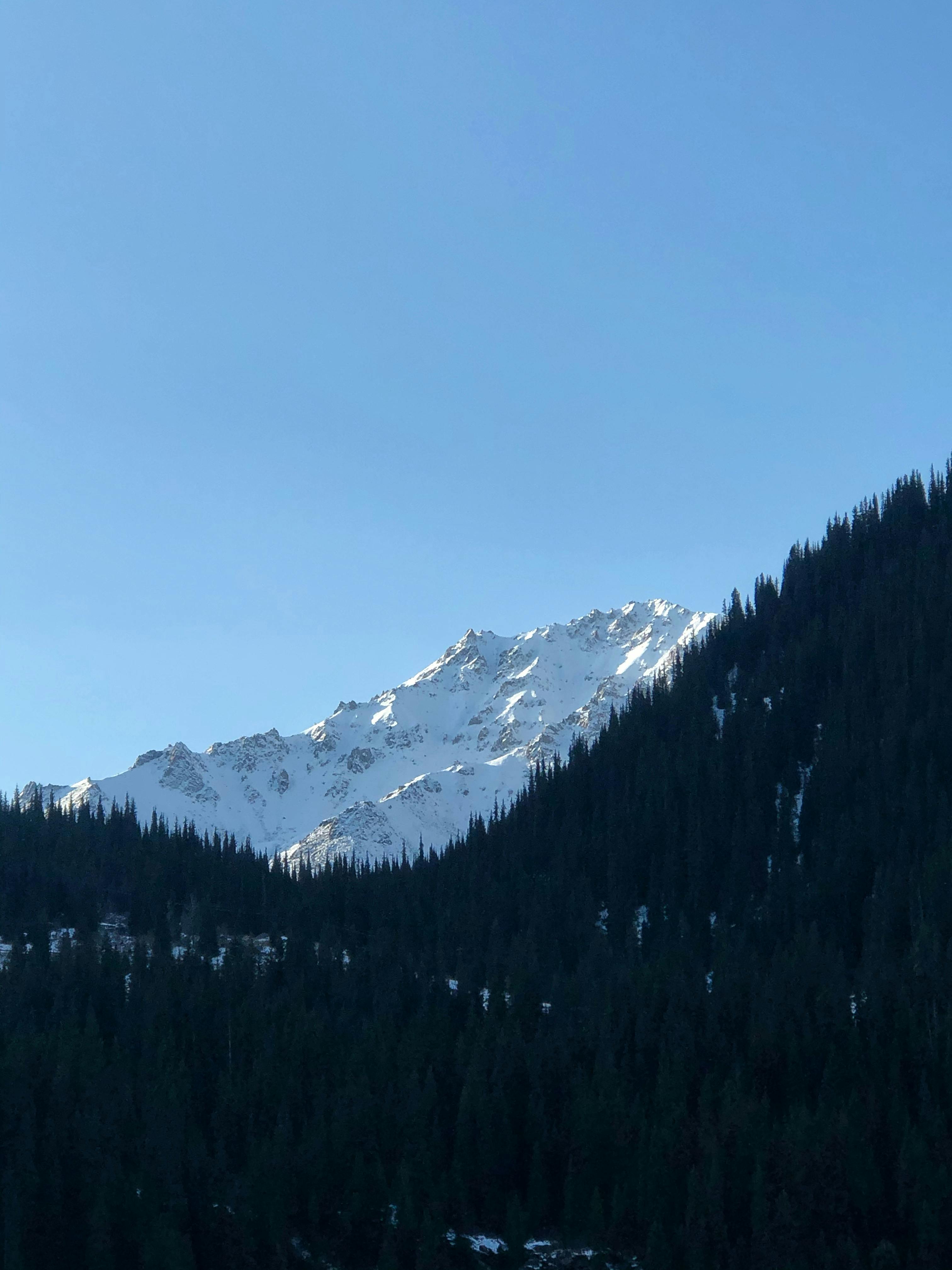 Majestic snow-capped mountains under a clear blue sky in Almaty, Kazakhstan.