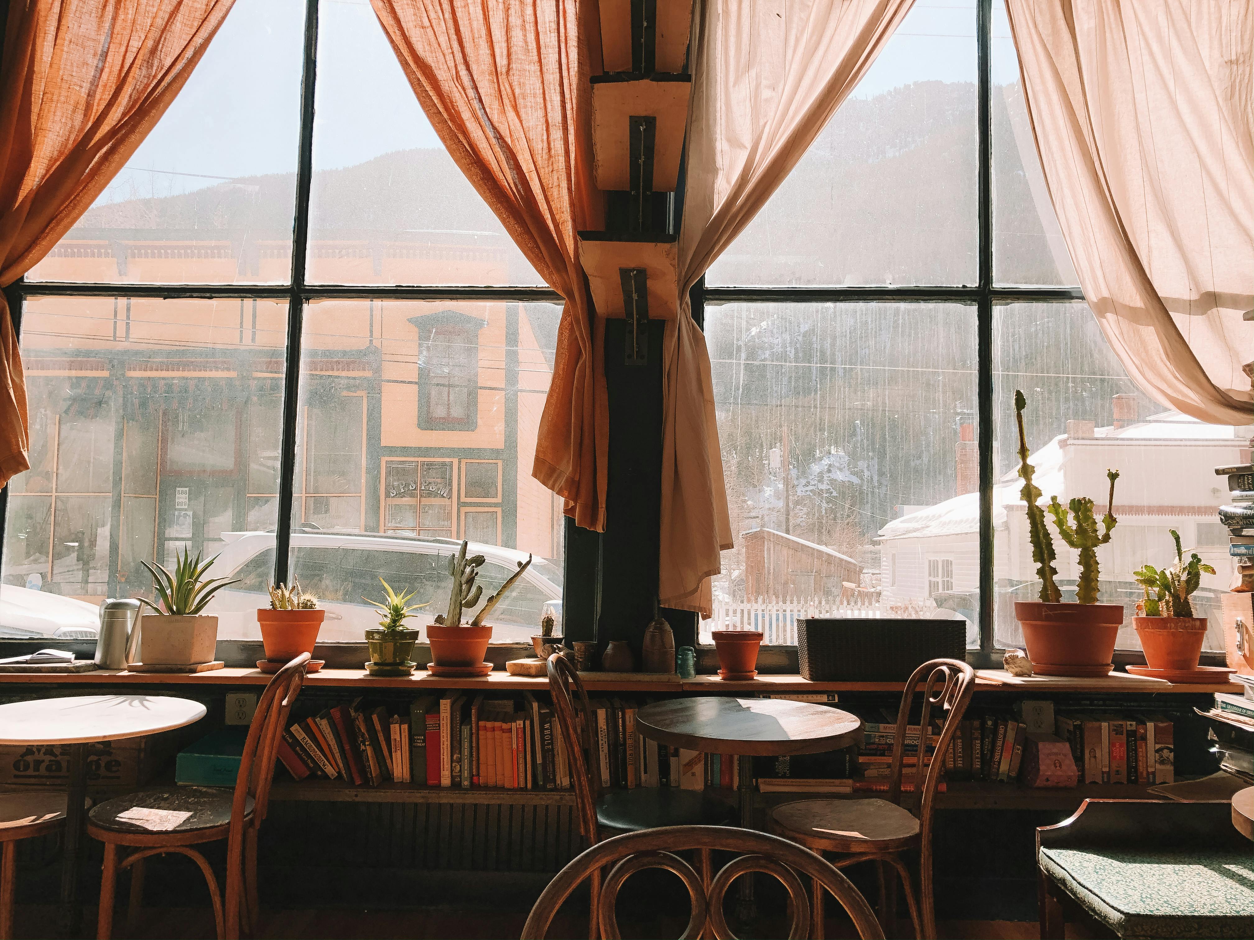 brown wooden table and chairs near window