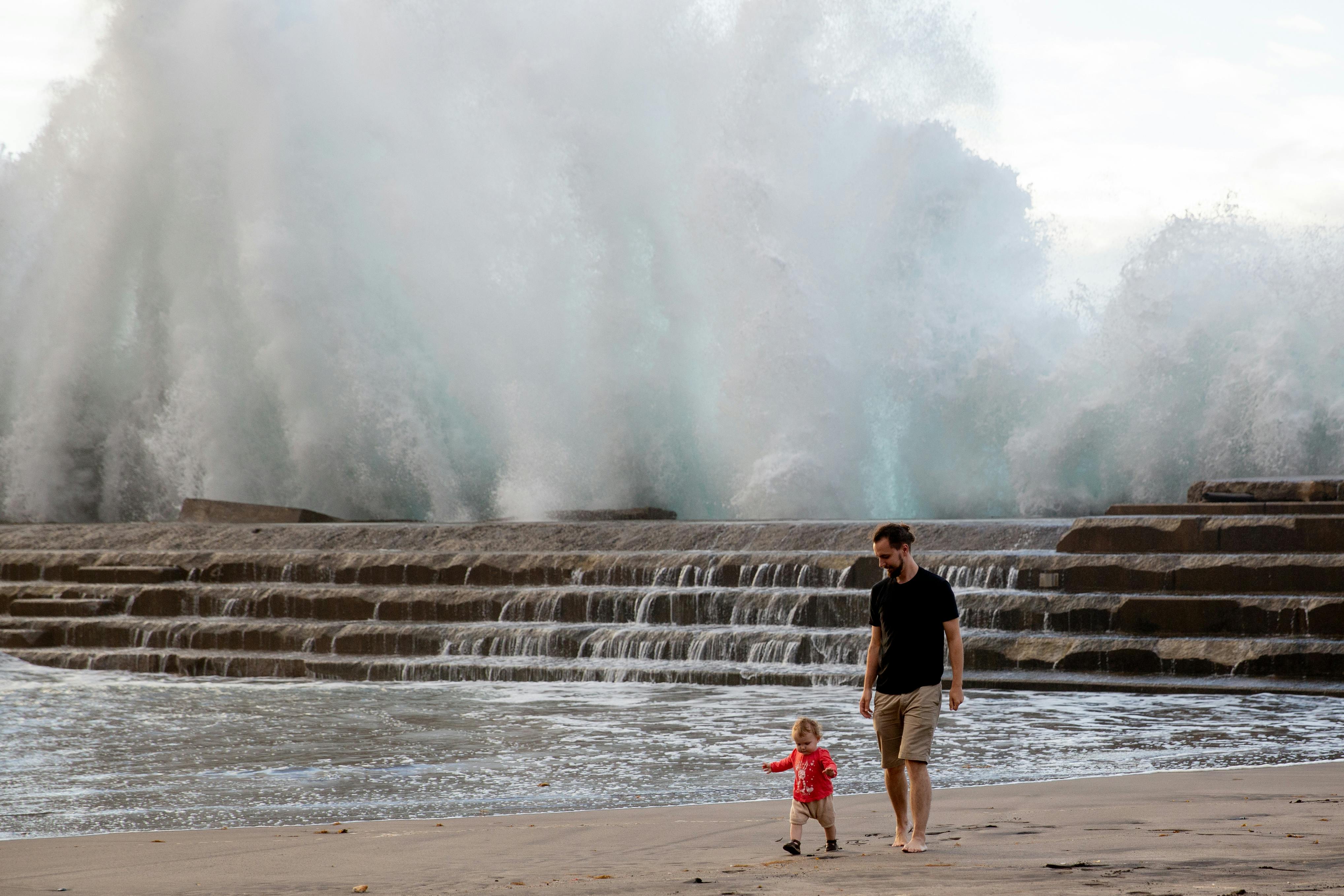 father and child walking on the shore