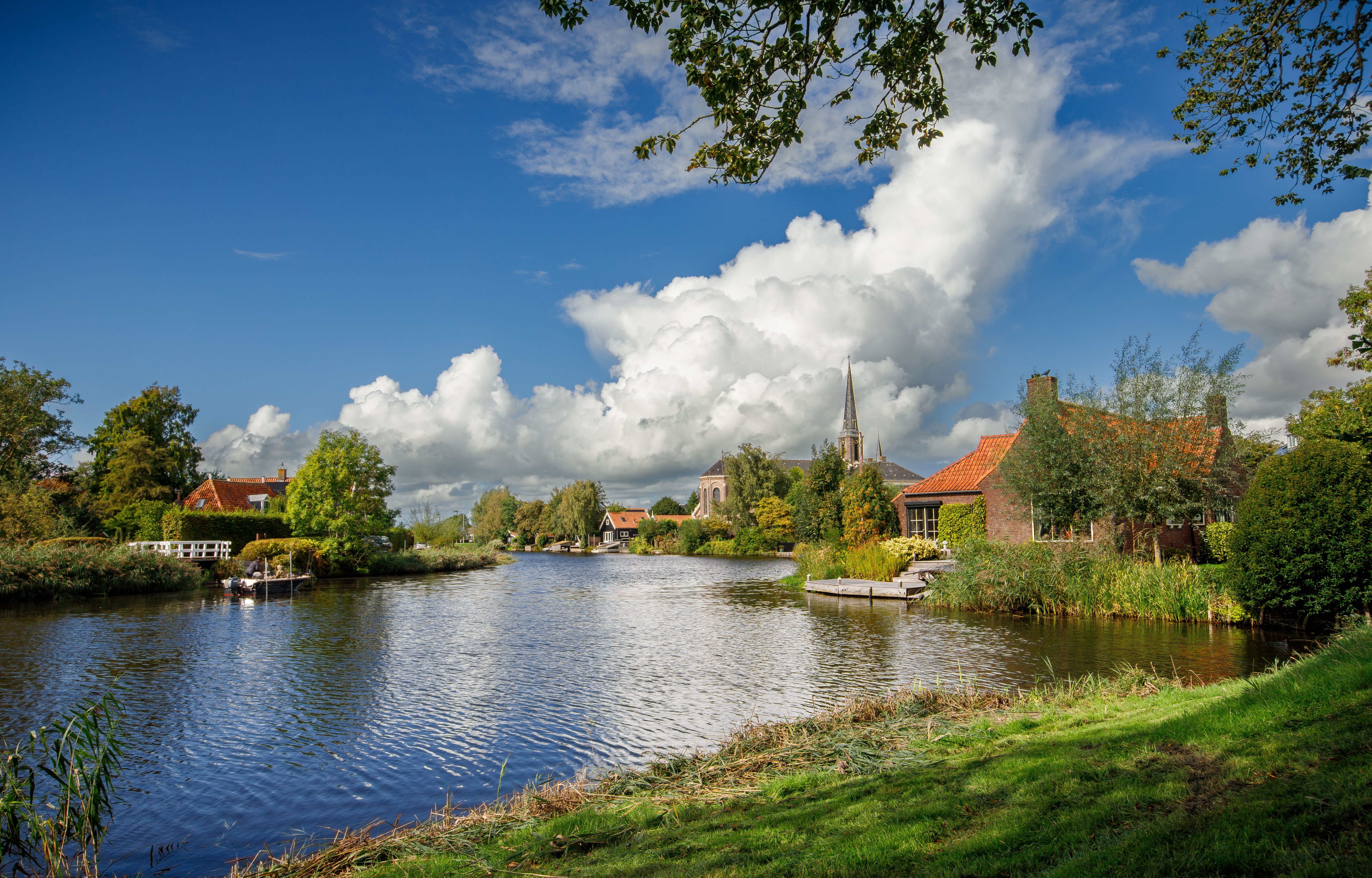 Beautiful summer landscape of Ilpendam, Netherlands, with a canal and church view.