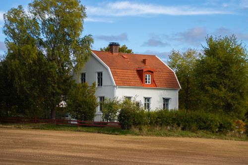 Free Picturesque countryside house with red roof in Jönköping, Sweden. Ideal rural living imagery. Stock Photo