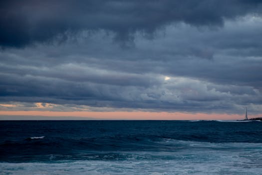 Dramatic clouds over the ocean at sunset, creating a captivating seascape view.