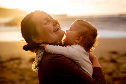 Free Close-Up Photo of Smiling Mother Carrying Her Baby Stock Photo