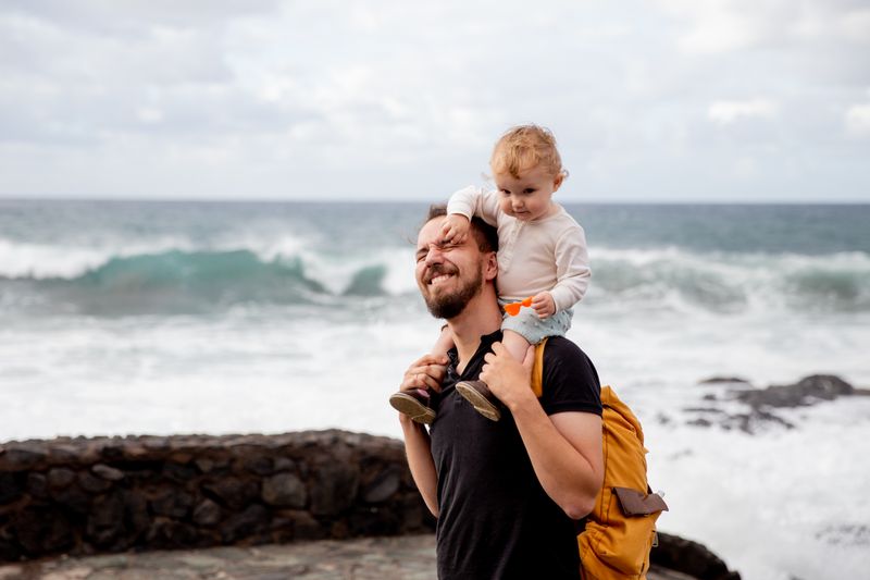Dad with his child on his shoulders outdoors