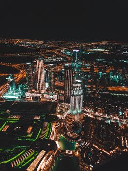 Stunning aerial view of Dubai's illuminated skyscrapers and cityscape at night, showcasing modern architecture.