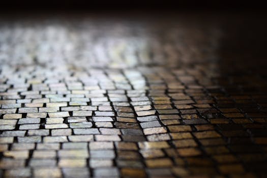 Close-up view of a wet cobblestone street texture with a reflective surface.