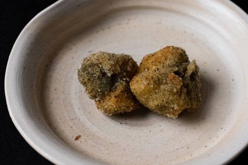 Free Two pieces of Japanese fried food on a ceramic plate, showcasing traditional cuisine. Stock Photo