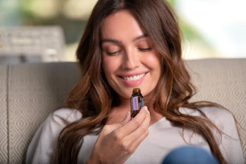 Free Woman Smiling Holding A Bottle Of Essential Oil Stock Photo