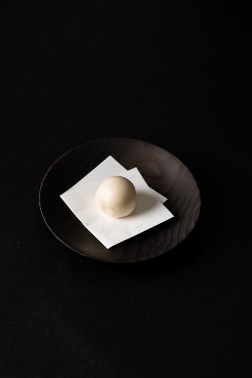 Free Minimalist presentation of a Japanese sweet on a wooden plate, perfect for culinary art and design enthusiasts. Stock Photo