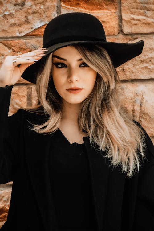 Free Beautiful Woman in Black Long Sleeve Shirt Wearing Black Hat Stock Photo