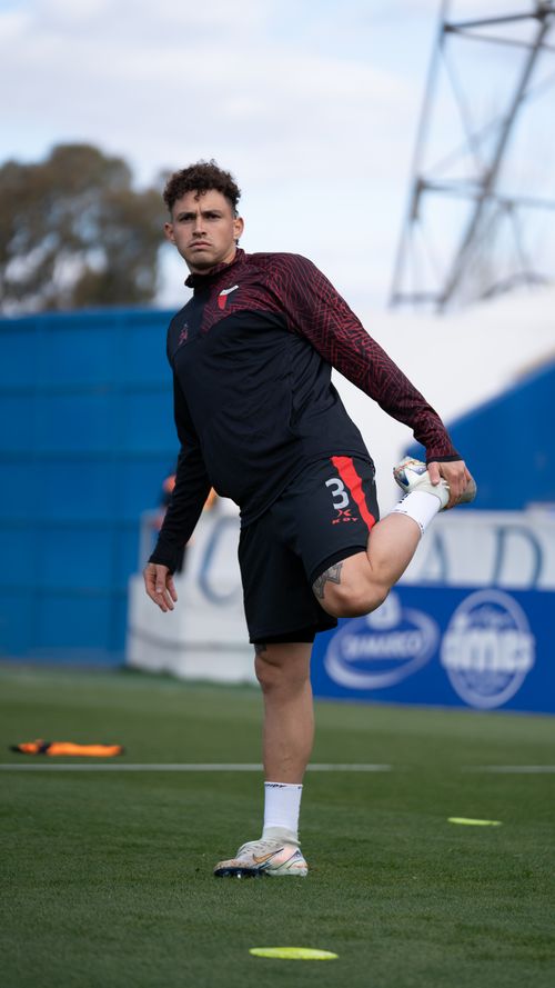 Free Soccer player stretching leg muscles during warm-up on the field. Stock Photo