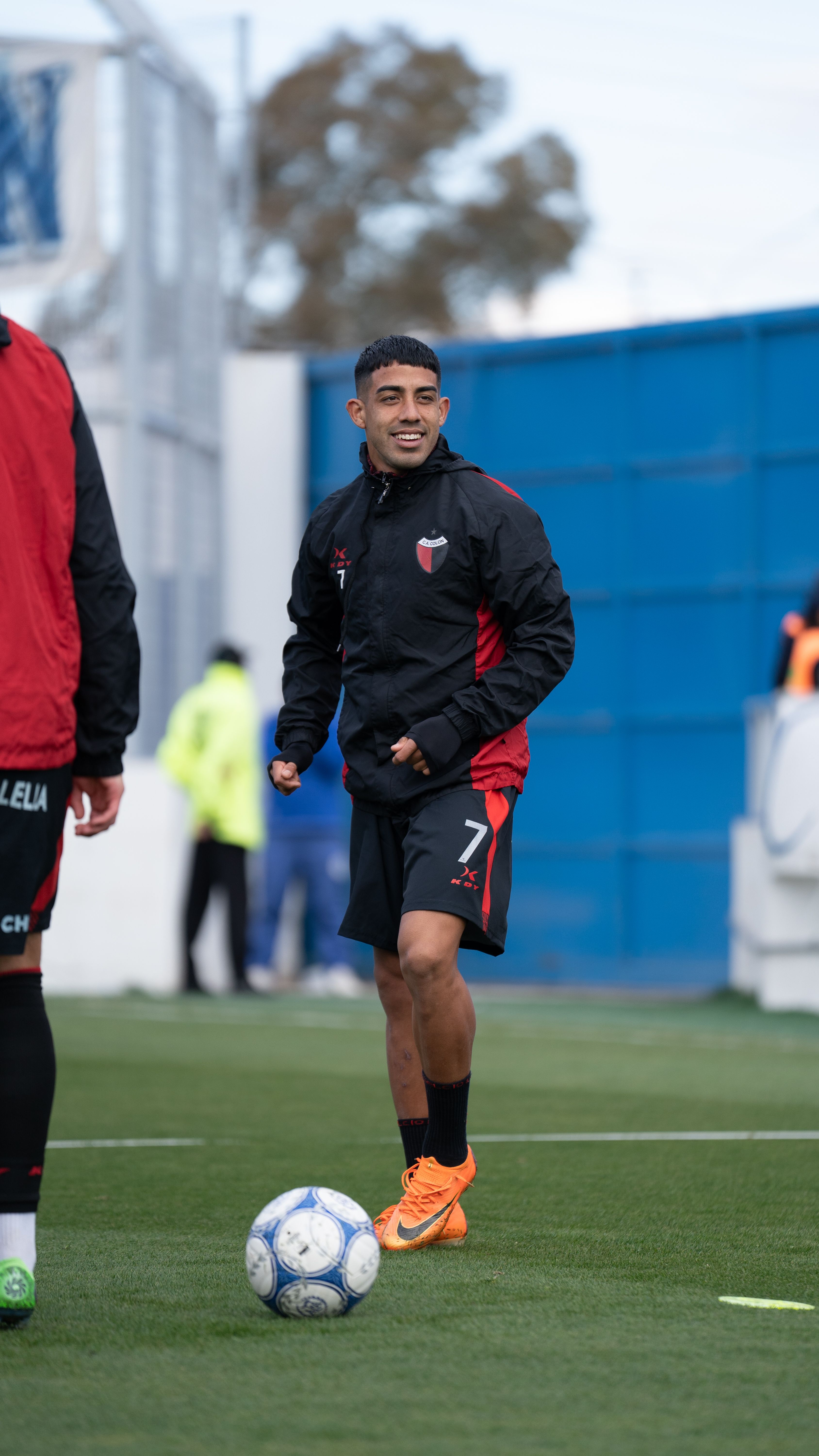 Soccer player enjoying training on an artificial turf field on a cool day.