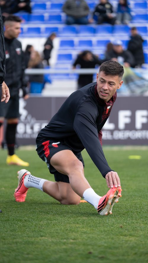 Free Male soccer player stretching during outdoor practice session on a grassy field. Stock Photo