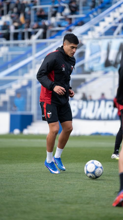 Free Soccer player in training session on a green field with modern stadium backdrop. Stock Photo
